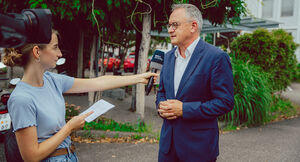 Der Landesvorsitzende der SPD Baden-Württemberg Andreas Stoch spricht im Freien in ein Mikrofon, das ihm eine Reporterin von SWR Aktuell hinhält.